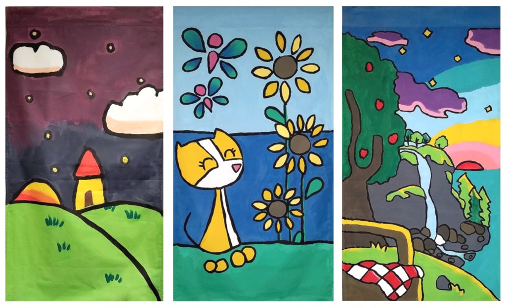Three banners painted by children. A hut on a hill. A cartoon kitten with sunflowers. A picnic at sunset.